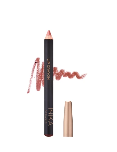 Na zdjęciu widoczna jest kredka do ust typu Lip Crayon marki INIKA Organic. Produkt ma czarny korpus z napisami w kolorze złota i matowe, złote zamknięcie. Obok kredki znajduje się próbka koloru – ciepły odcień różu w postaci miękkiej, kremowej kreski