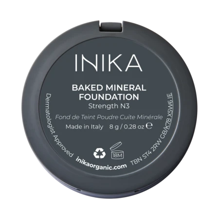 Na zdjęciu widoczny jest spód opakowania kompaktowego podkładu mineralnego marki INIKA Organic. Produkt opisany jest jako Baked Mineral Foundation w odcieniu Strength N3.