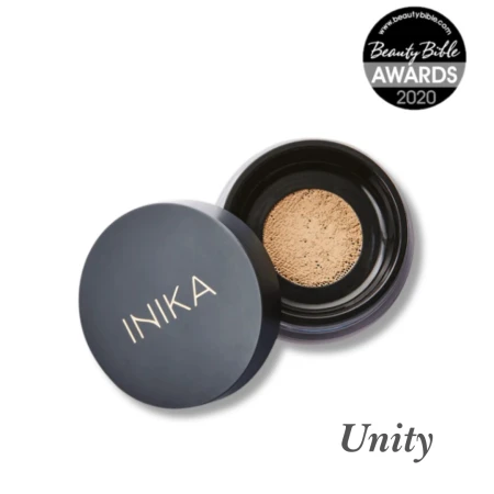 Na przesłanym zdjęciu widoczny jest słoiczek mineralnego pudru sypkiego marki INIKA Organic w odcieniu Unity. Opakowanie jest czarne z charakterystycznym złotym logo INIKA na zakrętce. Obok słoiczka znajduje się odznaczenie: Beauty Bible Awards 2020