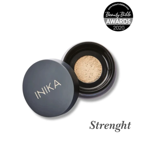 Na przesłanym zdjęciu widoczny jest słoiczek mineralnego pudru sypkiego marki INIKA Organic w odcieniu Strength. Opakowanie jest czarne z charakterystycznym złotym logo INIKA na zakrętce. Obok słoiczka znajduje się odznaczenie: Beauty Bible Awards 2020