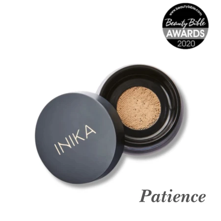 Na przesłanym zdjęciu widoczny jest słoiczek mineralnego pudru sypkiego marki INIKA Organic w odcieniu Patience. Opakowanie jest czarne z charakterystycznym złotym logo INIKA na zakrętce. Obok słoiczka znajduje się odznaczenie: Beauty Bible Awards 2020