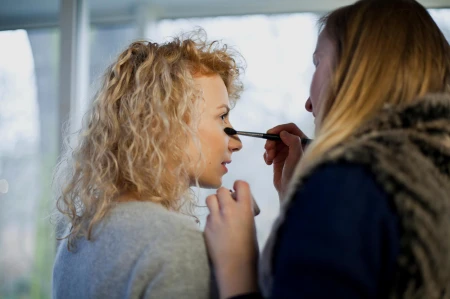 Zdjęcie oddaje profesjonalną, elegancką atmosferę miejsca – prawdopodobnie salonu lub punktu sprzedaży z usługą doradztwa makijażowego. Idealne do pokazania przebiegu lekcji makijażu dziennego lub promocji vouchera.