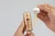 Na zdjęciu kobiece dłonie trzymahą butelkę serum Purles 143 VitC Serum Perfector w lewej dłoni. Druga dłoń trzyma pipetę, którą wyjęto z buteleczki – w pipetce znajduje się odrobina płynnego, lekko pomarańczowego serum.