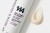 Na zdjęciu widoczna jest butelka kremu Purles 144 VitC Cream Perfector w białym, smukłym opakowaniu z fioletowymi i czarnymi napisami. Obok opakowania znajduje się próbka produktu – krem w odcieniu jasnego beżu, o kremowej, gładkiej konsystencji.