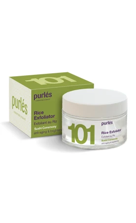 Na zdjęciu jestprodukt marki Purlés Rice Exfoliator 101. Jest to peeling ryżowy w przezroczystym słoiczku z białą nakrętką. Na froncie słoiczka znajduje się napis „101 Rice Exfoliator”, a obok jest zielony kartonik opakowania z białymi napisami.