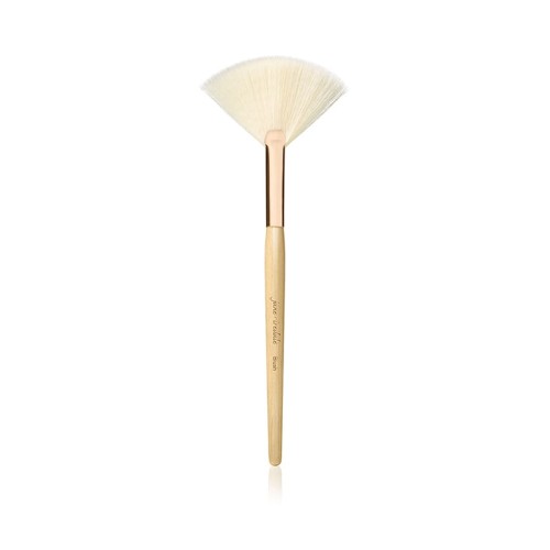 Na zdjęciu znajduje się wachlarzowy pędzel marki Jane Iredale. Jest to lekki, wachlarzowaty pędzel z jasnym włosiem, idealny do: aplikacji rozświetlacza, usuwania nadmiaru pudru, konturowania. Smukły trzonek z naturalnego drewna z złotą skuwką