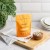 Zdjęcie przedstawia stojące, pomarańczowe opakowanie suplementu diety w kapsułkach Rejuvenated Re-set. Produkt jest opisany jako naturalny suplement diety wspierający zdrowy metabolizm komórkowy, energię i spalanie tłuszczu.
