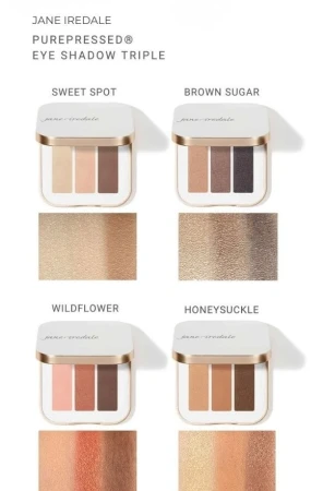 Na zdjęciu są cztery potrójne palety cieni do powiek Jane Iredale. Zawierają po trzy odcienie o różnorodnej tonacji a pod nimi są próbki kolorów na dłoni o jasnej karnacji.