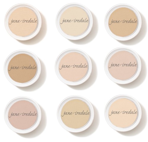 Na zdjęciu widać dziewięć okrągłych pudrów w wersji mini marki Jane Iredale, ułożonych w siatkę 3x3. Każdy z nich ma inny odcień – od bardzo jasnych po nieco ciemniejsze tonacje, idealne do dopasowania do różnych typów cery.