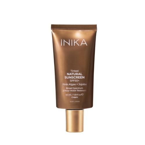 Na zdjęciu jest produkt INIKA Tinted Natural Sunscreen SPF50+ w brązowo-złotej tubie z matowym wykończeniem i złotą zakrętką. Na opakowaniu znajdują się informacje na temat produktu.