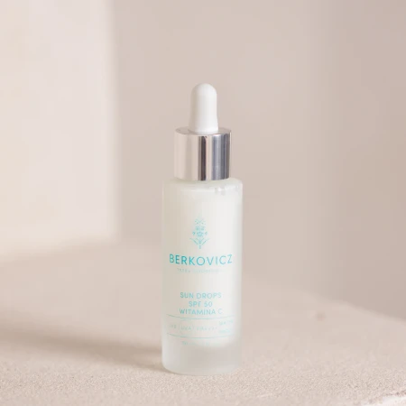 Eleganckie, minimalistyczne ujęcie produktu Berkovicz Tatra Cosmetics – Sun Drops SPF 50 Witamina C na jasnym tle. Smukła butelka z pipetą i srebrnym wykończeniem podkreśla precyzyjną aplikację