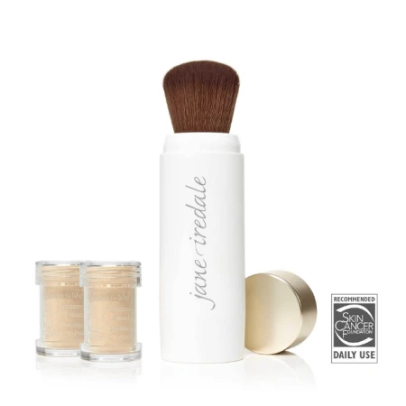 Na zdjęciu jest pędzel zintegrowany z pudrem sypkim  marki Jane Iredale Powder-Me SPF. Produkt składa się z eleganckiego, białego pojemnika z miękkim, zaokrąglonym pędzlem oraz dwóch przezroczystych wkładów z pudrem ochronnym.