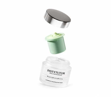 Grafika przedstawia krem INSTYTUTUM SuperBiotic Regeneration Cream na białym tle. Nad otwartym słoiczkiem unoszą się wkład z jasnozielonym kremem oraz srebrna nakrętka, prezentując system wymiennego wkładu.