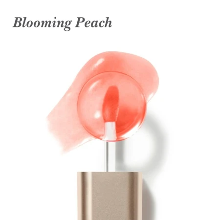 Na białym tle jest aplikator olejku do ust Jane Iredale Just Kissed Lip Oil z miękką, zaokrągloną końcówką w koralowym odcieniu. W tle widoczna jest rozsmarowana próbka olejku w brzoskwiniowo-koralowym kolorze, o transparentnej, błyszczącej konsystencji.
