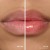 Zdjęcie typu „przed i po” przedstawia zbliżenie ust modelki. Po lewej usta mają naturalny, delikatnie różowy kolor, a po prawej, po aplikacji olejku Jane Iredale Just Kissed Lip Oil, są bardziej brzoskwiniowo-różowe, wygładzone i wyraźnie błyszczące.