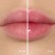 Zdjęcie typu „przed i po” przedstawia zbliżenie ust modelki. Po lewej usta mają naturalny, delikatnie różowy kolor, a po prawej, po aplikacji olejku Jane Iredale Just Kissed Lip Oil, zyskują intensywniejszy różowy odcień