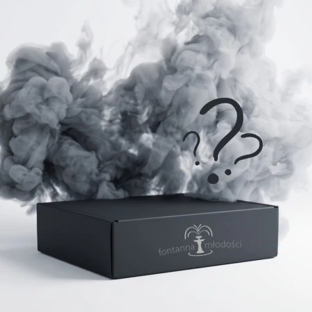 Na zdjęciu czarny Mystery Box marki Fontanna Młodości ze srebrnym logo na froncie. Nad zamkniętym pudełkiem unoszą się kłęby szarego i czarnego dymu, a widoczne wśród nich znaki zapytania podkreślają tajemniczą zawartość zestawu.