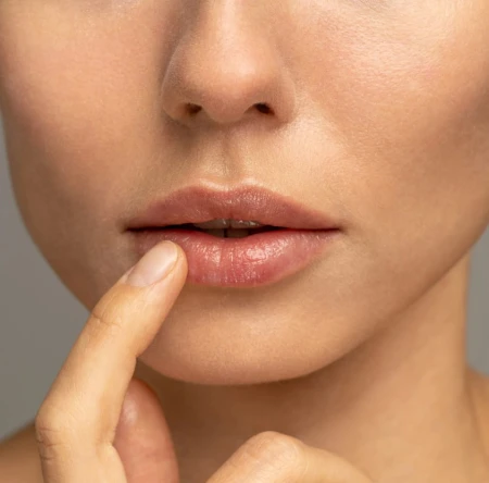 Modelka w makijażu gdzie użyto na ustach JANE IREDALE 24-Karat GOLD DUST - uniwersalny złoty pyłek. Usta mają odcień złota, sa rozświetlone i zmysłowe.