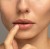 Modelka w makijażu gdzie użyto na ustach JANE IREDALE 24-Karat GOLD DUST - uniwersalny złoty pyłek. Usta mają odcień złota, sa rozświetlone i zmysłowe.