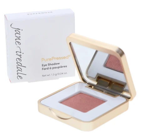 Cień do powiek Supernova z serii PurePressed® Eye Shadow marki Jane Iredale to metaliczny, ciepły róż z nutą miedzi i subtelnym połyskiem. Złoto biały kompakt jest półotwarty.